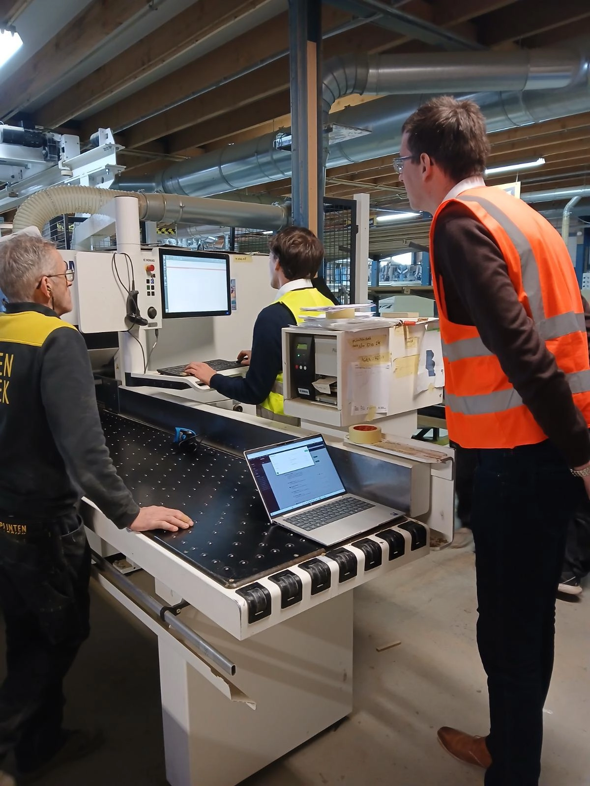 ERP-consultant werkt samen met medewerkers aan een productieproces